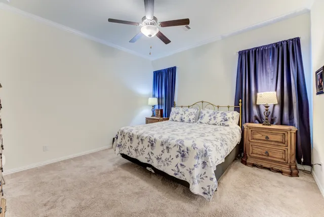 a bedroom with a large bed and a chandelier