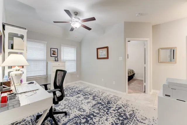 a view of a workspace with furniture and a window