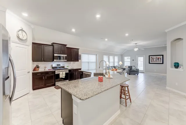 a large kitchen with a large counter top appliances and cabinets