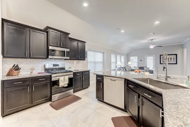 a kitchen with stainless steel appliances granite countertop sink stove top oven and microwave