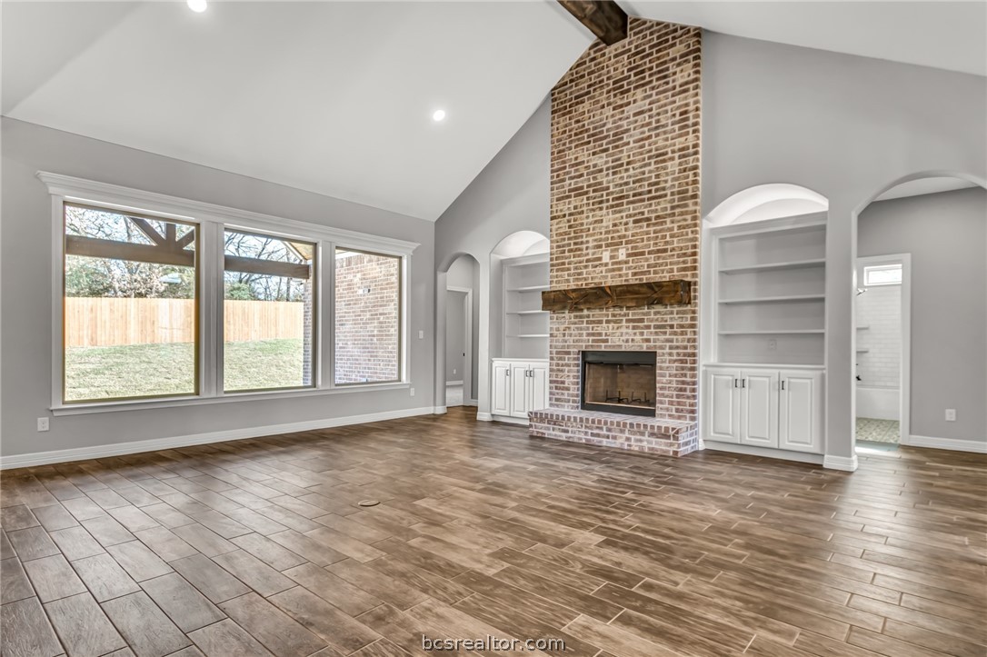a view of an empty room with a fireplace and a window