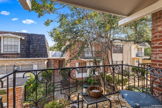a view of a brick house with large windows and a table