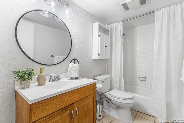 a bathroom with a sink a mirror a toilet and a shower