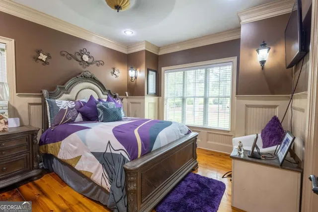 a bedroom with a bed a couch and a flat screen tv