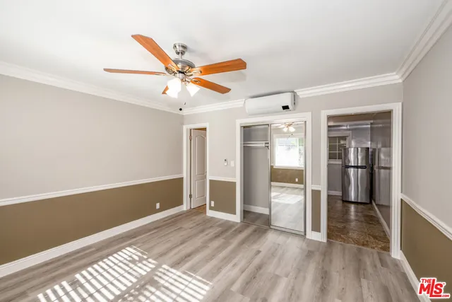 a view of a livingroom with wooden floor and a ceiling fan