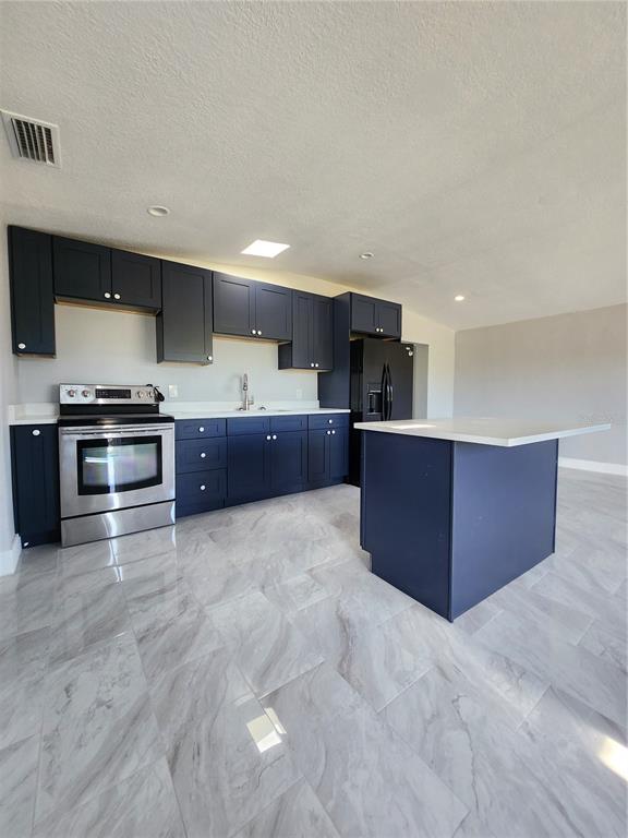 1302 West Shell Point Road Ruskin, FL 33570 - Photo 3 of 10 a large kitchen with stainless steel appliances granite countertop a stove and cabinets
