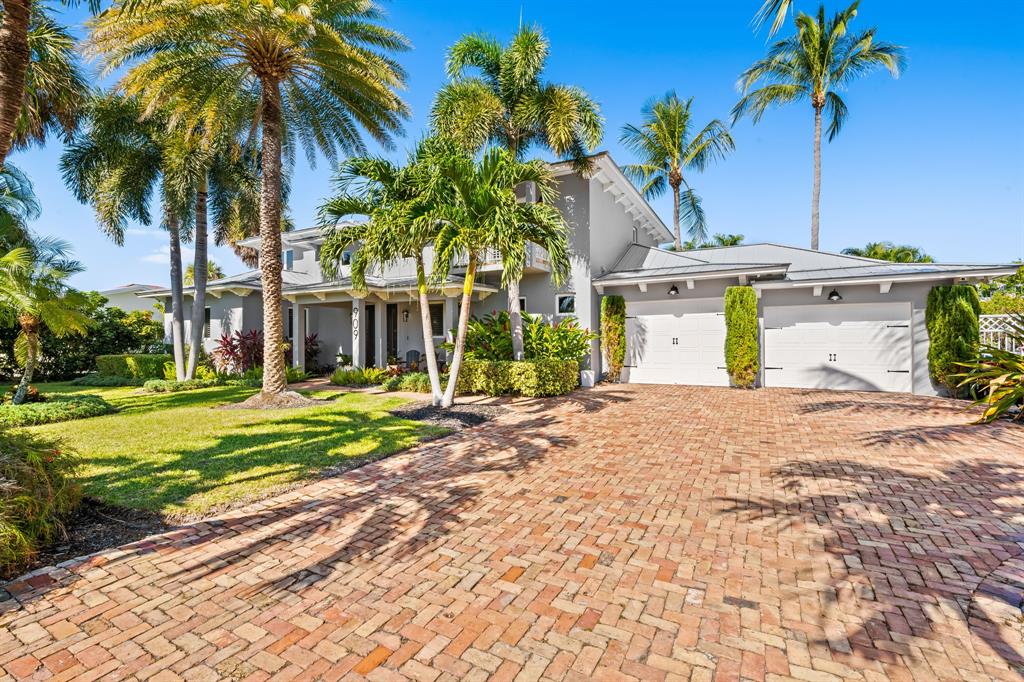 a view of a house with a yard and palm trees