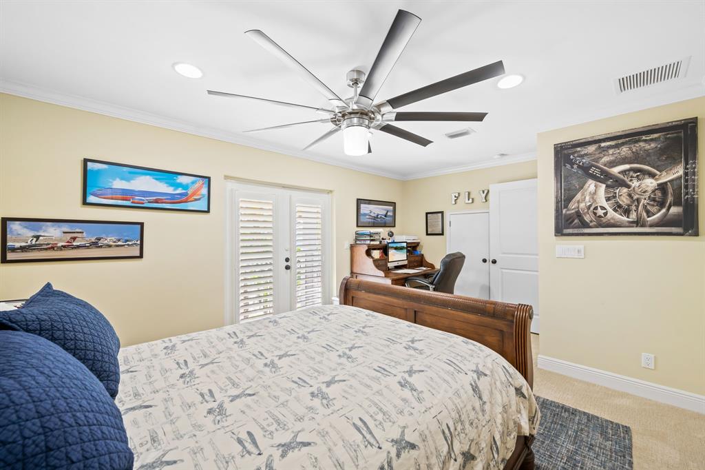909 Turner Road Delray Beach, FL 33483 - Photo 29 of 50 a bedroom with a bed and a chandelier