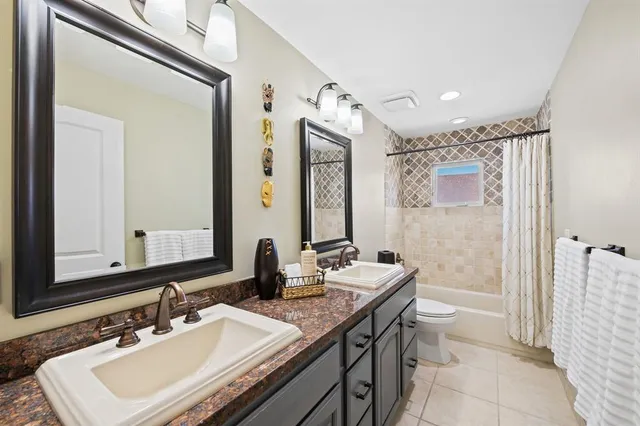 a bathroom with a sink vanity granite and a toilet