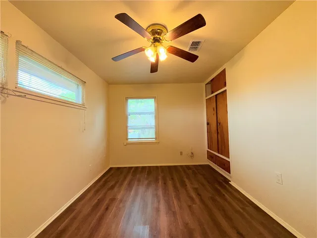a view of empty room with wooden floor