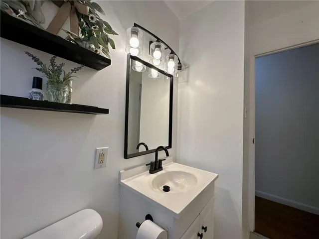 a bathroom with a toilet sink and mirror