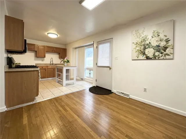 a view of a kitchen with wooden floor and a window