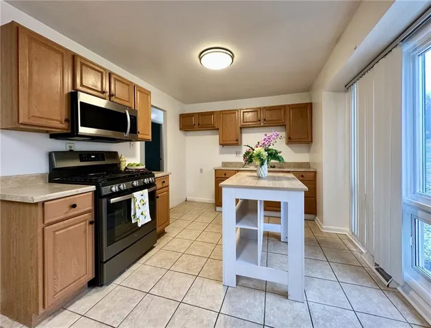 a kitchen with stainless steel appliances kitchen island granite countertop a stove cabinets and a sink