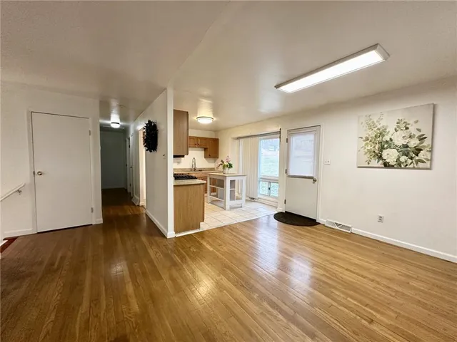a view of a kitchen with wooden floor and a refrigerator
