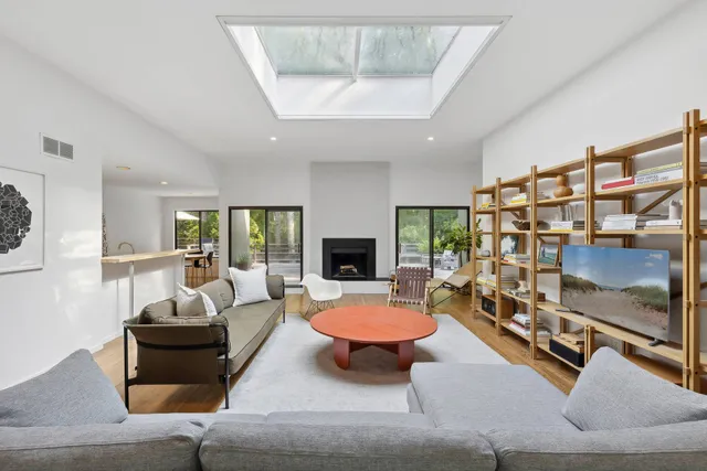 a living room with furniture fireplace and a large window