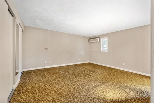 a bedroom with a bed and painting on the wall