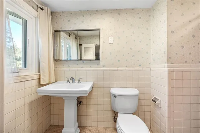 a white toilet sitting next to a bath tub