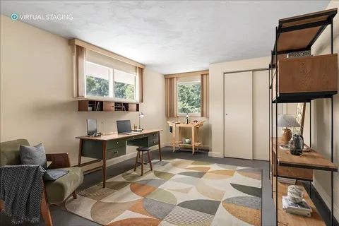 a view of a workspace with furniture and a window