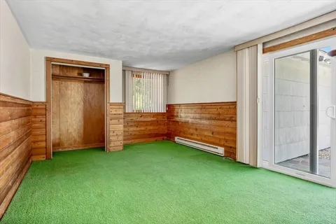 a view of an empty room with closet and windows