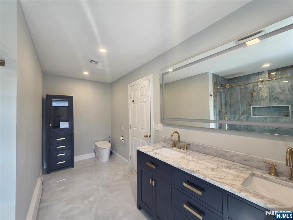 194 8th Street Cresskill, NJ 07626 - Photo 21 of 34 a bathroom with a granite countertop sink a toilet and a mirror