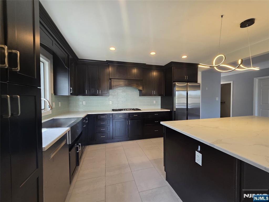 194 8th Street Cresskill, NJ 07626 - Photo 9 of 34 a kitchen with stainless steel appliances granite countertop a sink wooden cabinets and wooden floor
