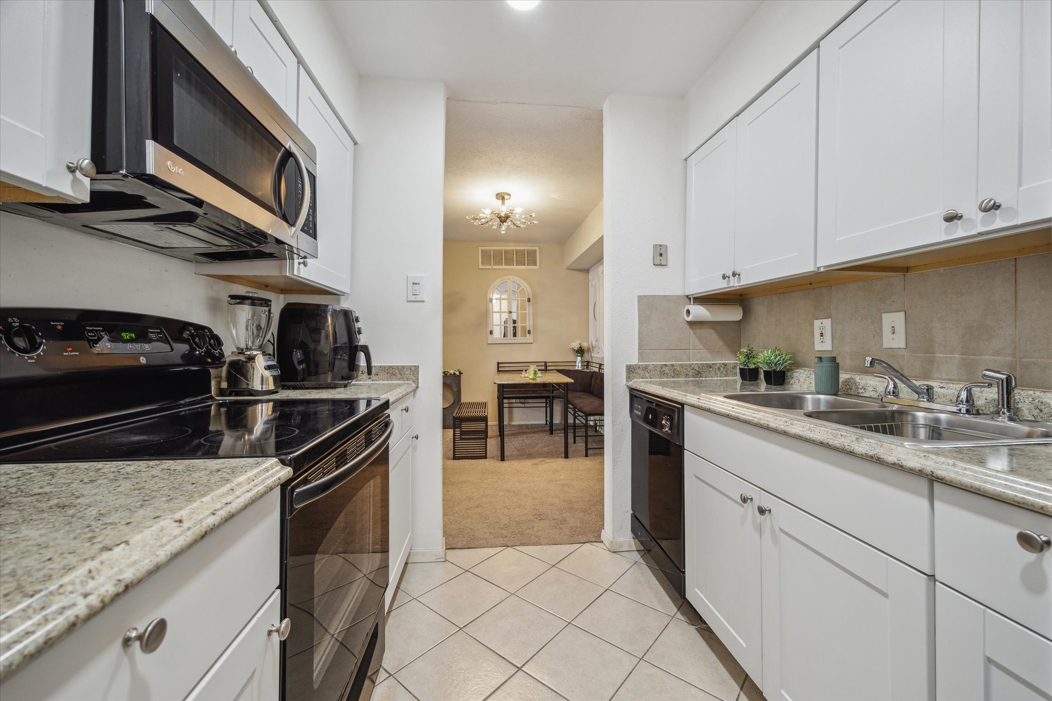 5667 Birchmont Drive, Unit A Houston, TX 77091 - Photo 11 of 18 a kitchen with stainless steel appliances granite countertop a sink stove and cabinets