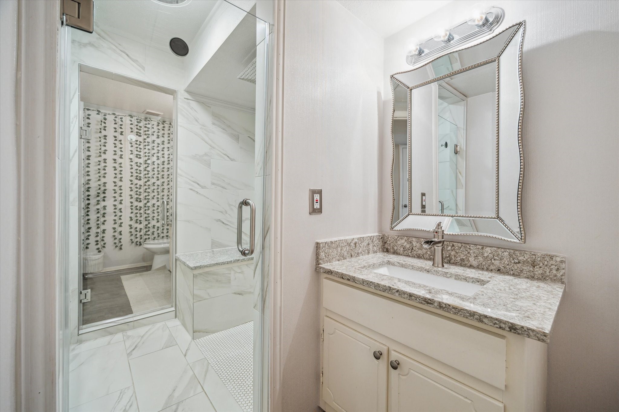 5667 Birchmont Drive, Unit A Houston, TX 77091 - Photo 15 of 18 a bathroom with a granite countertop sink a mirror and a shower