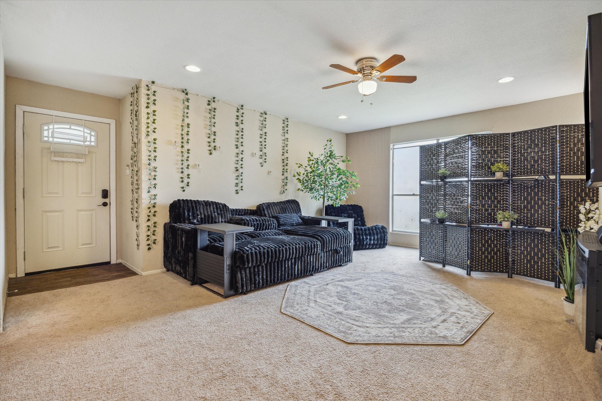 5667 Birchmont Drive, Unit A Houston, TX 77091 - Photo 5 of 18 a living room with furniture a chandelier and a rug