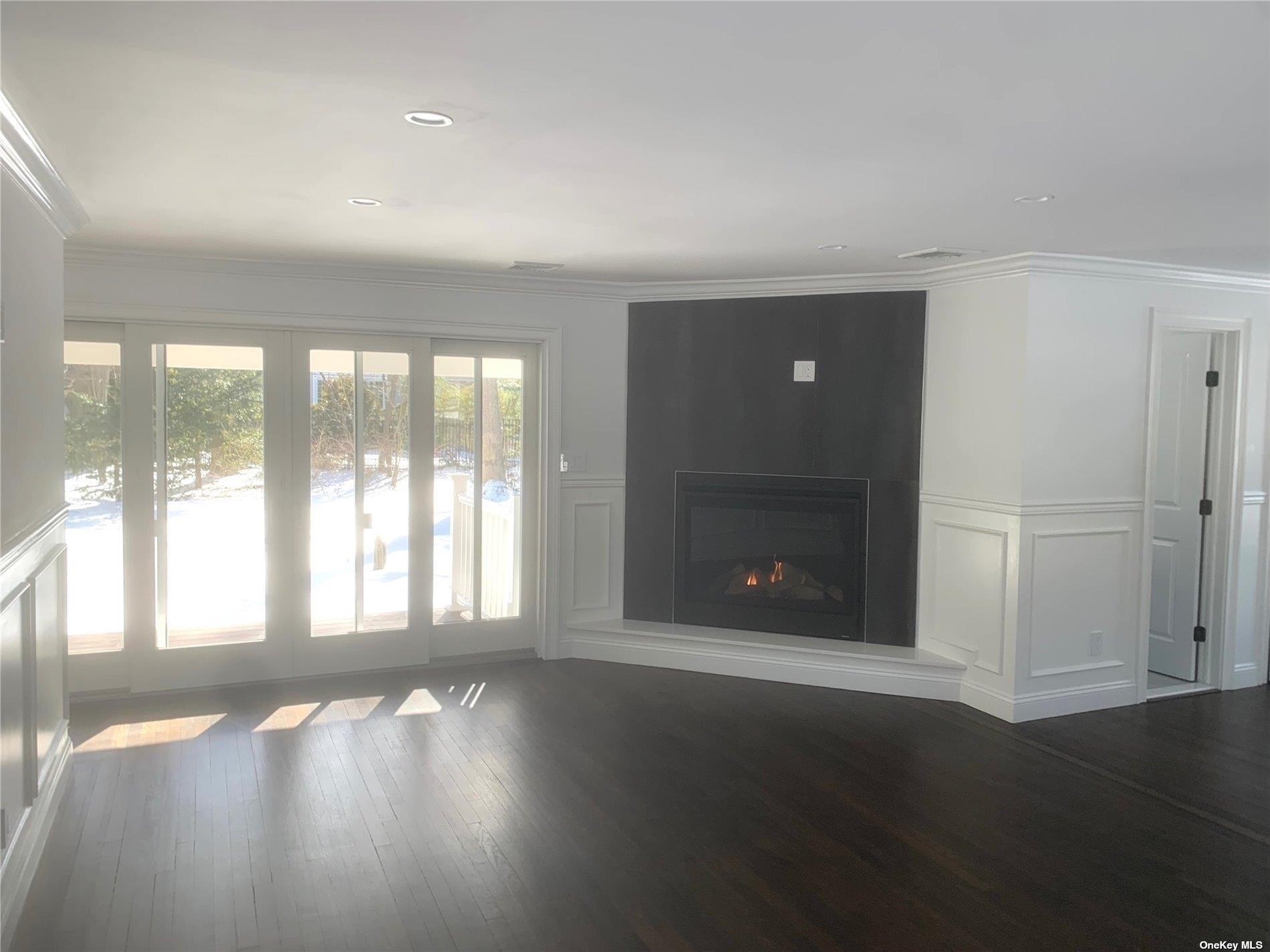 70 Nancy Boulevard Merrick, NY 11566 - Photo 4 of 7 an empty room with wooden floor and windows