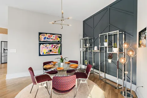 a view of a dining room with furniture a chandelier and wooden floor