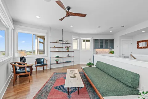 a living room with furniture a dining table and a floor to ceiling window