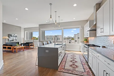 a large kitchen with stainless steel appliances granite countertop a lot of counter space and wooden floor