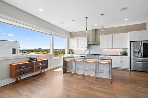 a kitchen with stainless steel appliances granite countertop a stove a sink and a refrigerator