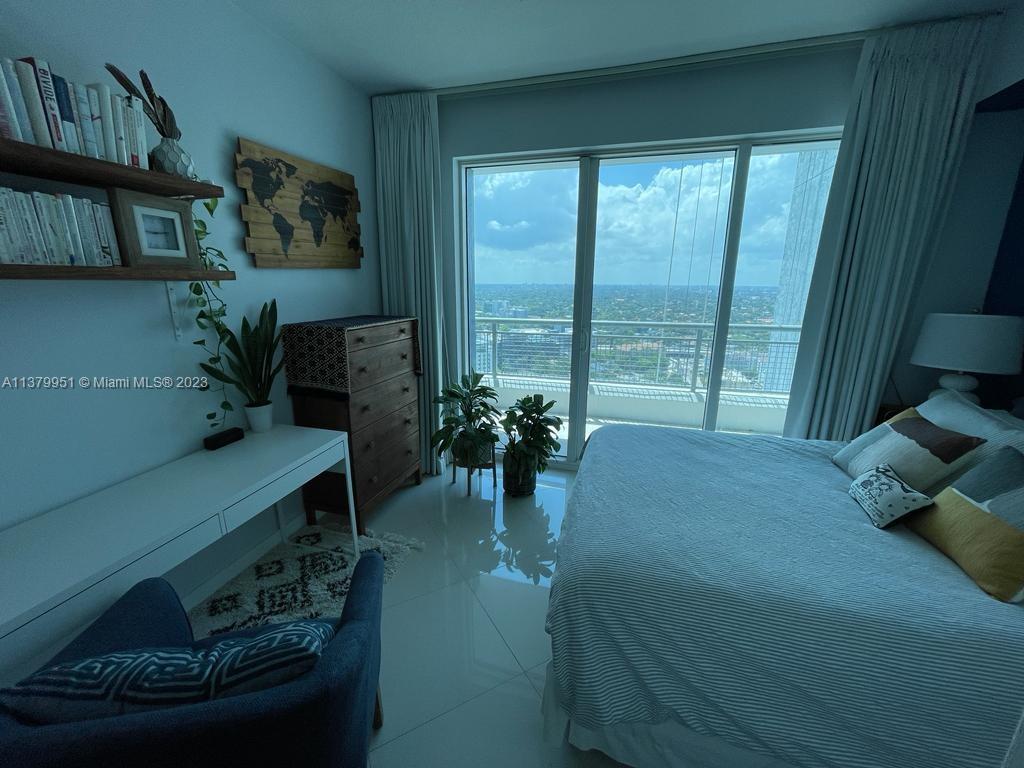 60 Southwest 13th Street, Unit 2413 Miami, FL 33130 - Photo 12 of 27 a bed sitting in a bedroom next to a window