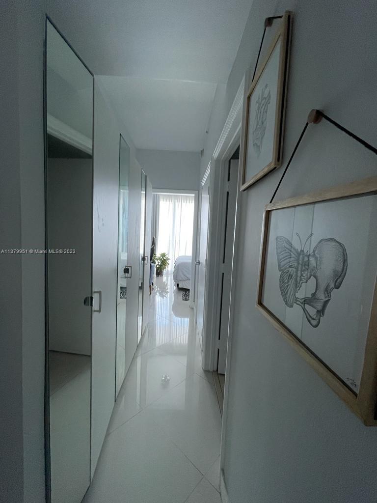 60 Southwest 13th Street, Unit 2413 Miami, FL 33130 - Photo 14 of 27 a view of a hallway with wooden floor and a bathroom