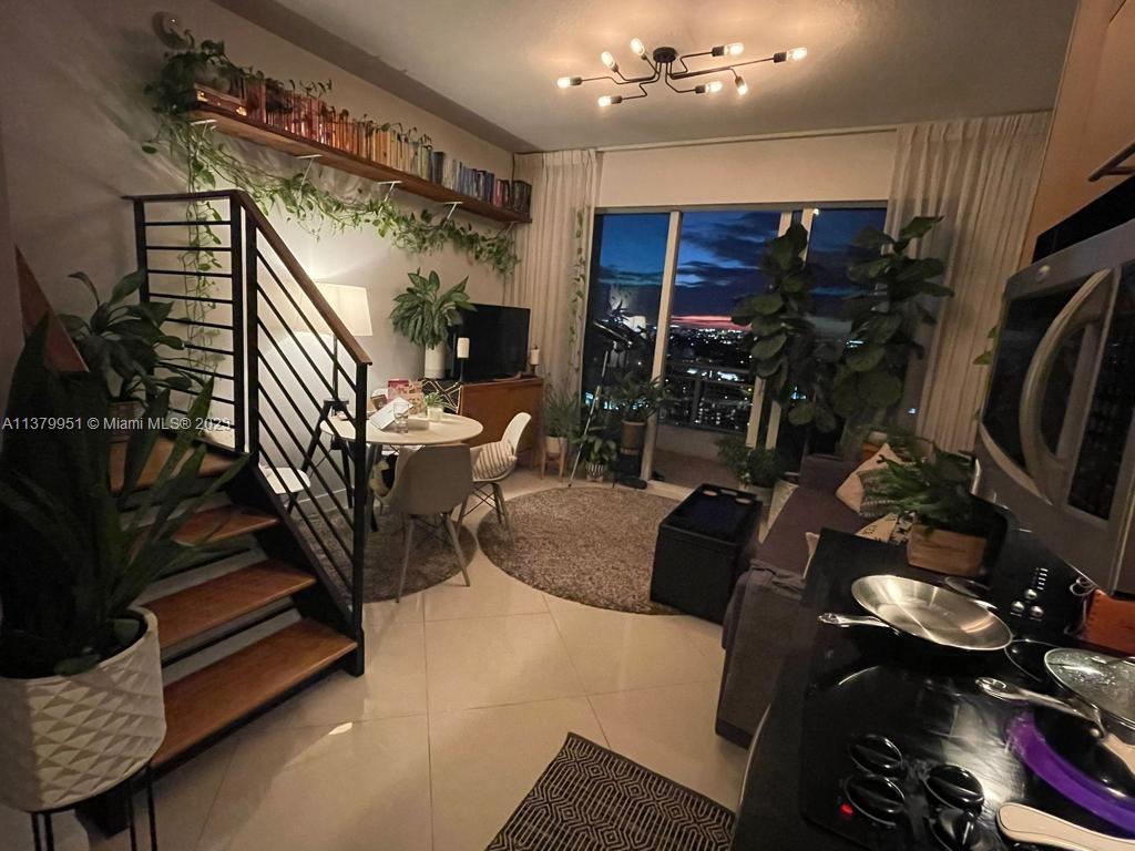 60 Southwest 13th Street, Unit 2413 Miami, FL 33130 - Photo 9 of 27 a living room with furniture and a flat screen tv