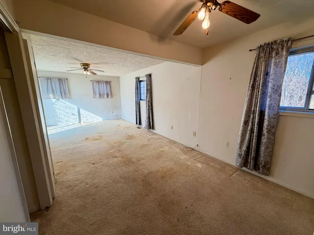 en empty room with windows and fireplace