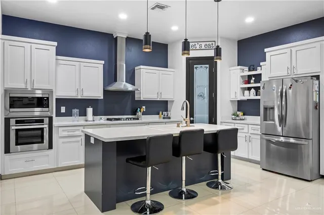 a kitchen with a sink a refrigerator and chairs