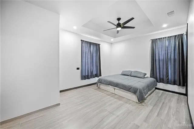 a spacious bedroom with a bed and a ceiling fan