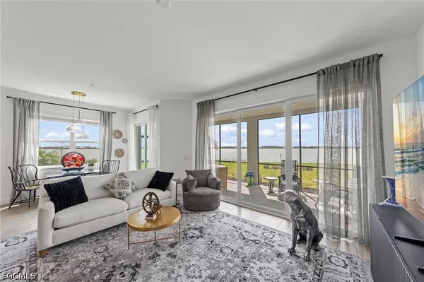 a living room with furniture a rug and a view of kitchen