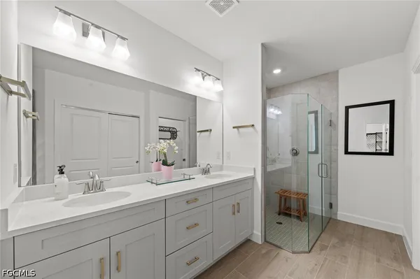 a bathroom with a double vanity sink mirror and shower