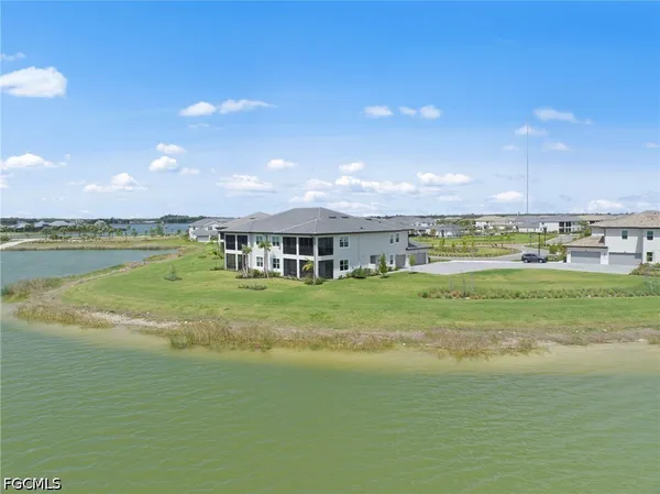an aerial view of a house with outdoor space and a lake view in back