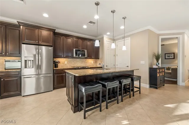 a kitchen with stainless steel appliances granite countertop a sink a stove and a refrigerator