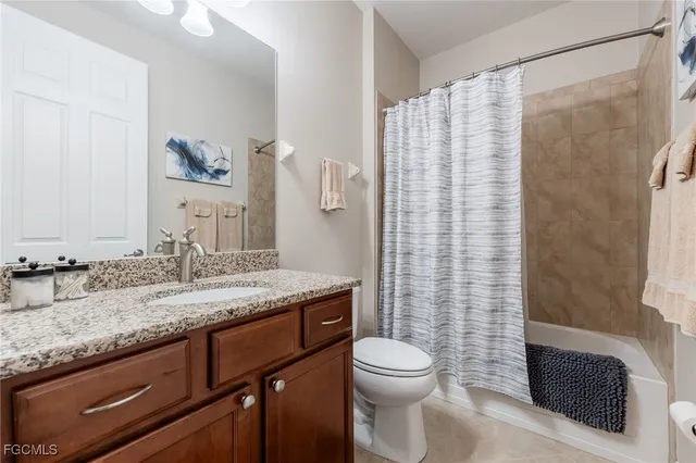 a bathroom with a granite countertop sink a toilet and shower