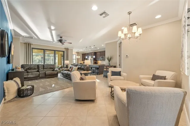a living room with furniture a chandelier and a dining room