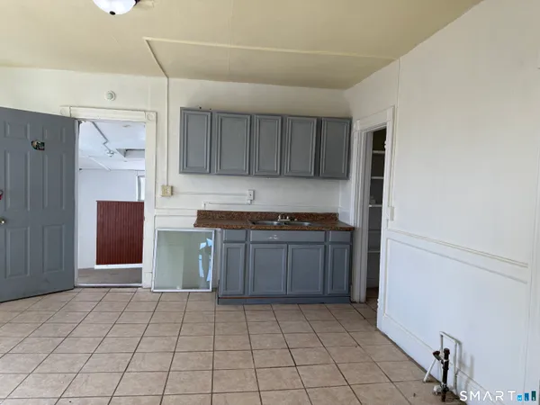 a kitchen with granite countertop a refrigerator and a stove top oven