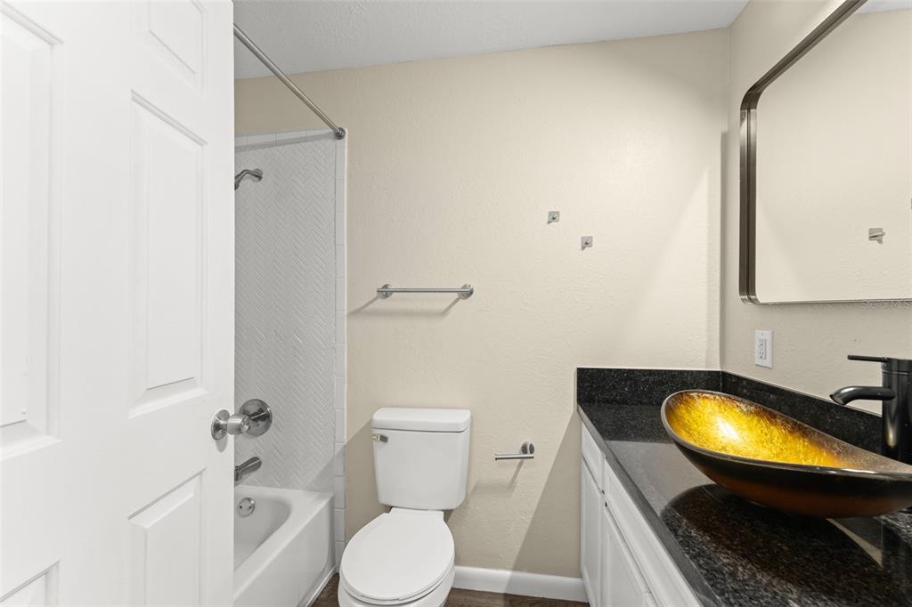 247 Toms Road DeBary, FL 32713 - Photo 17 of 31 a bathroom with a granite countertop sink toilet and a mirror