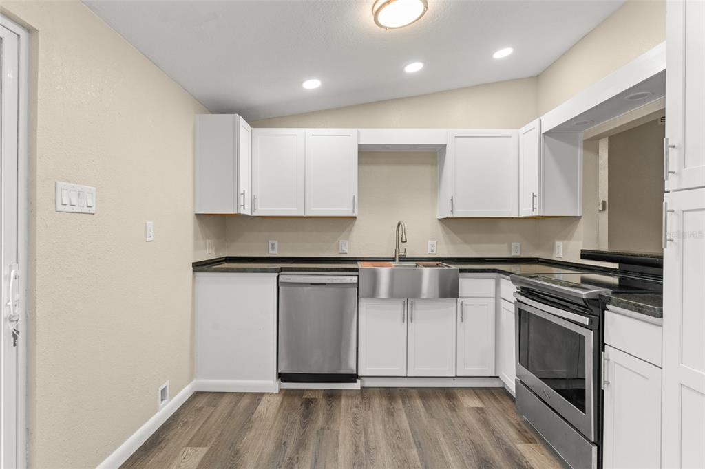 247 Toms Road DeBary, FL 32713 - Photo 9 of 31 a kitchen with stainless steel appliances granite countertop a stove and a refrigerator