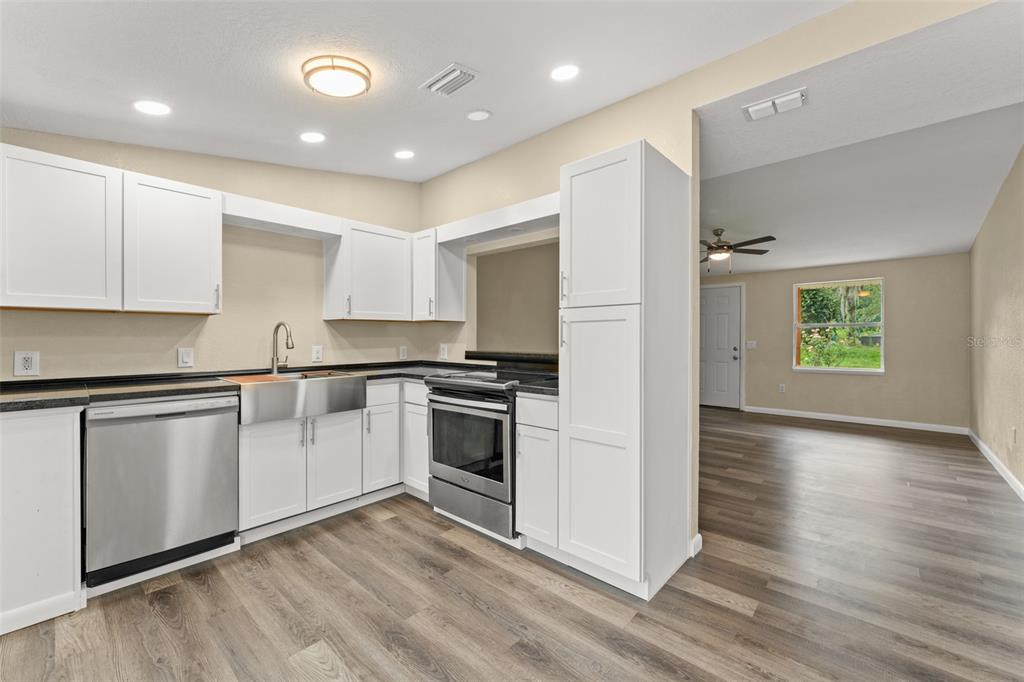 247 Toms Road DeBary, FL 32713 - Photo 10 of 31 a kitchen with granite countertop white cabinets and stainless steel appliances
