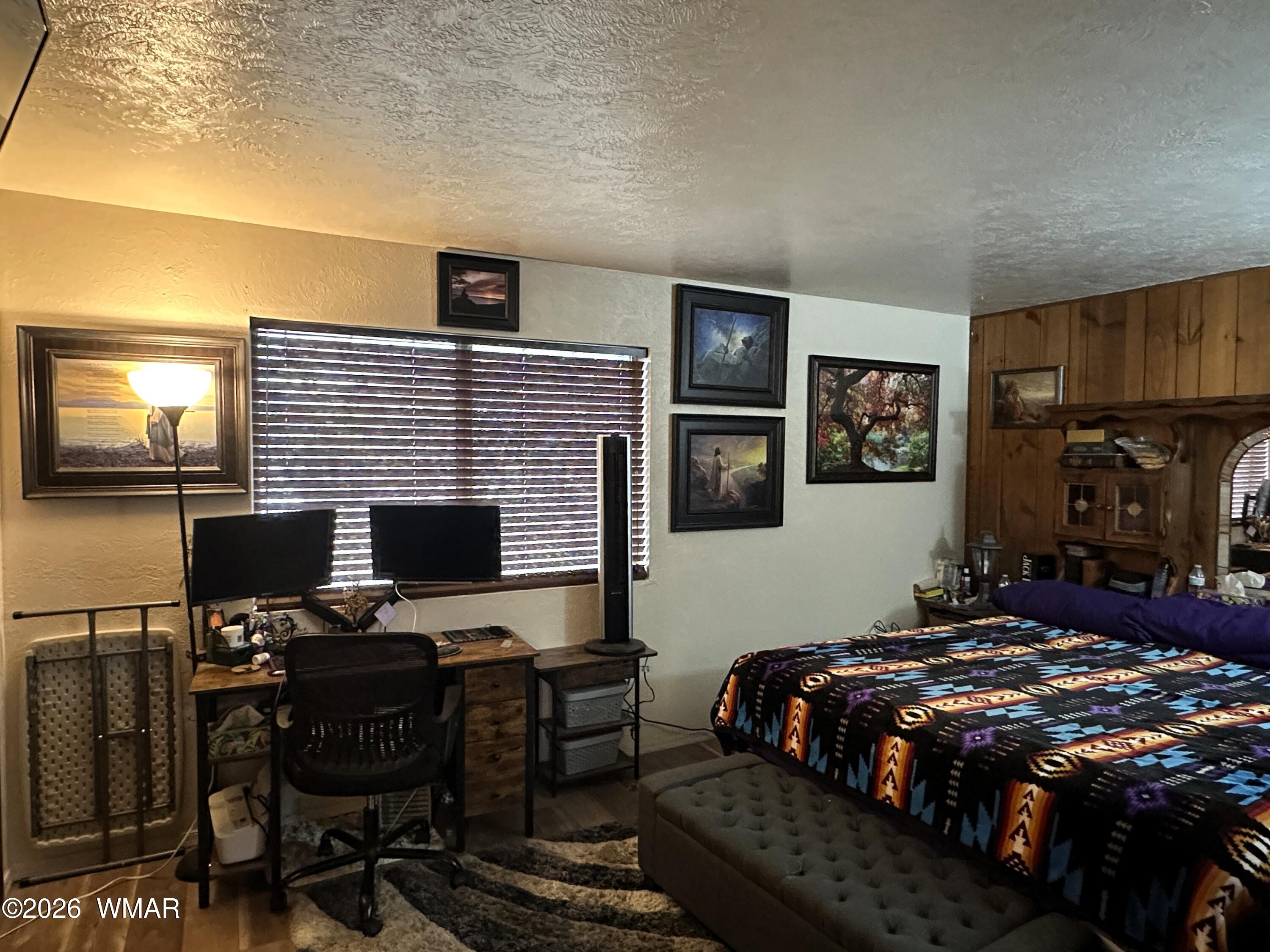 19 County Road Alpine, AZ 85920 - Photo 13 of 27 a bedroom with a bed and a computer on a desk next to a window